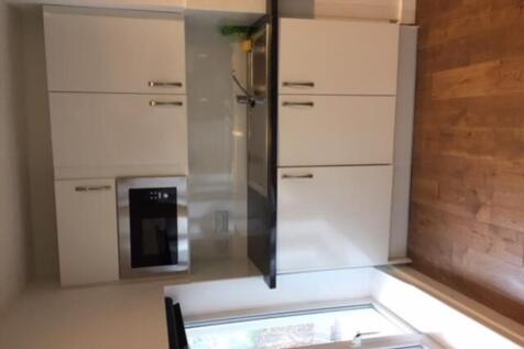 A modern kitchenette featuring sleek cabinetry ...