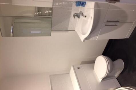 A modern and tidy bathroom featuring sleek fixt...