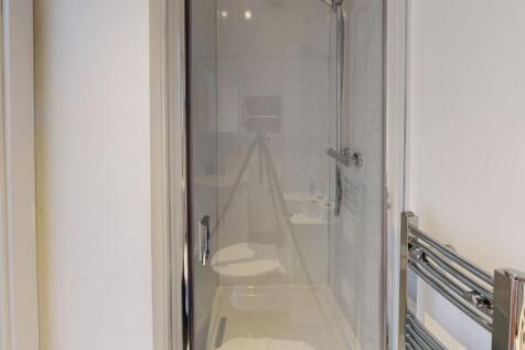 A modern bathroom suite featuring a clear glass...