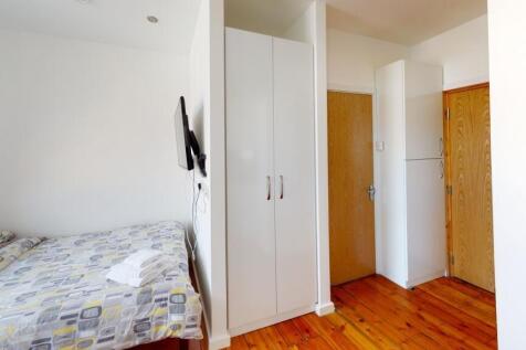 A bright and clean compact bathroom featuring a...