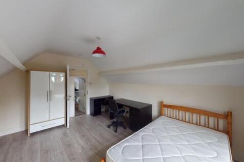 A tidy and simple attic bedroom featuring a sin...