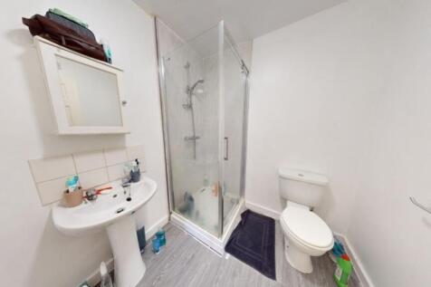 A modern bathroom suite featuring a clear glass...