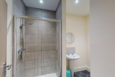 A modern bathroom featuring a walk-in tiled sho...