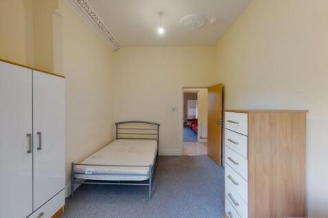 A simple and tidy bedroom featuring a single be...