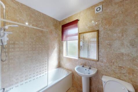 A spacious and modern bathroom featuring a bath...