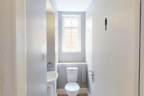 Bright and clean single toilet with a window al...