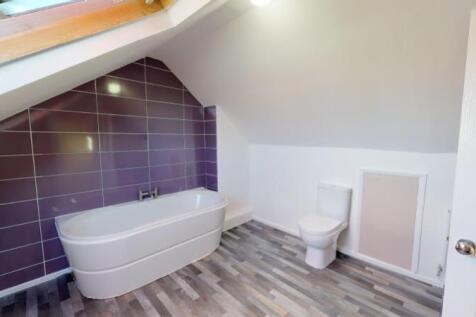 A modern bathroom suite featuring a sleek batht...