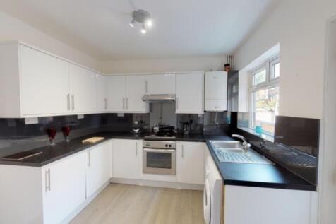 Bright and modern kitchen featuring white cabin...