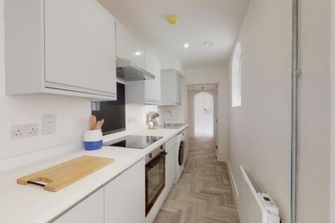 A modern and clean kitchenette with ample natur...