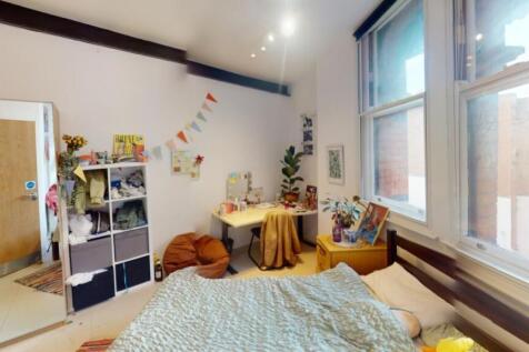 Bright and spacious master bedroom with large w...