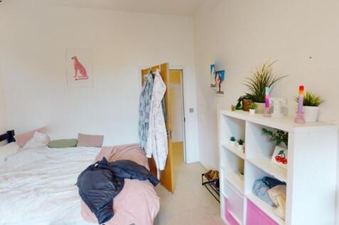 Bright and cozy master bedroom featuring a comf...