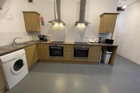 A modern kitchen featuring dual ovens and hobs,...