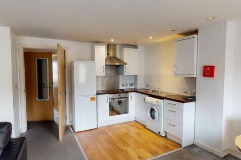Modern kitchen area with white cabinetry, integ...