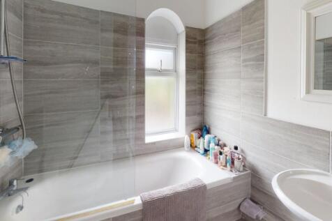 A modern bathroom suite featuring a bathtub wit...