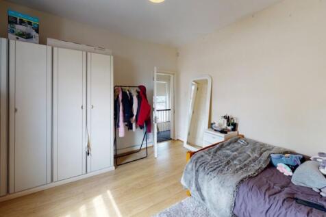 A bright and tidy double bedroom featuring ligh...