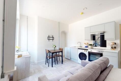 A bright and modern kitchenette with ample spac...