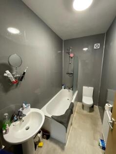 A modern bathroom featuring a clean white batht...