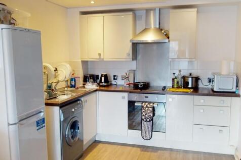 A modern kitchen featuring white cabinetry, a w...