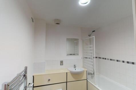 Bright and clean bathroom featuring a bathtub w...