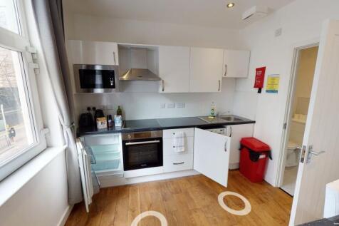 Bright and modern kitchen featuring white cabin...