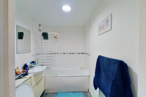 A bright and clean bathroom suite featuring a b...