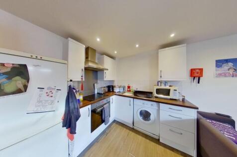 Bright and modern kitchen featuring white cabin...