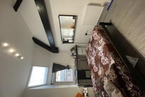 A cozy double bedroom featuring exposed ceiling...