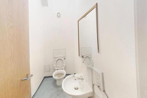 A clean and minimalist single toilet room featu...