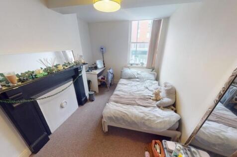 A cozy double bedroom featuring two single beds...