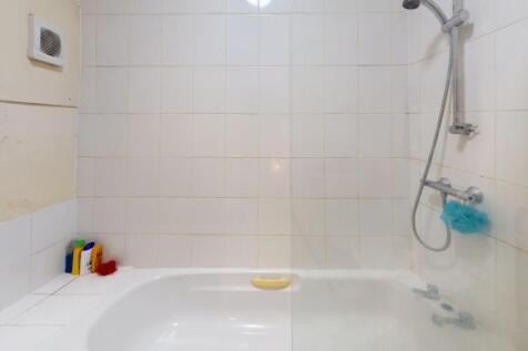 Bright and clean bathroom featuring a white til...