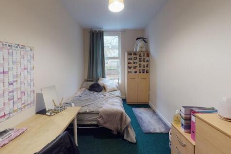 A tidy and functional single bedroom with a com...