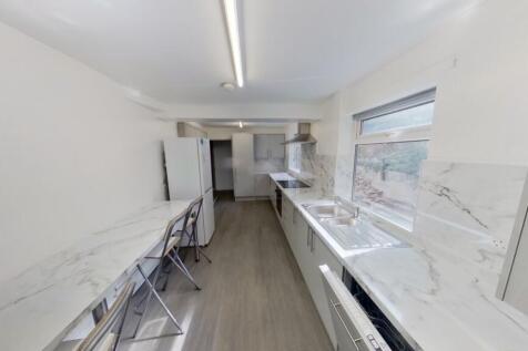 A modern kitchen featuring sleek marble-effect ...