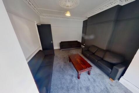 A modern living room featuring dark sofas and a...