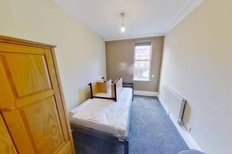 A tidy single bedroom with a comfortable bed, w...