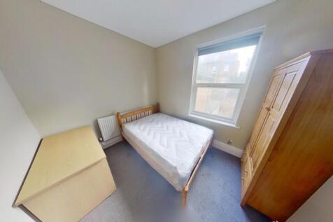 A cozy single bedroom featuring a comfortable b...