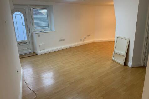 A spacious and clean living room featuring ligh...