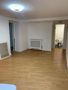 A clean and spacious living room with light woo...