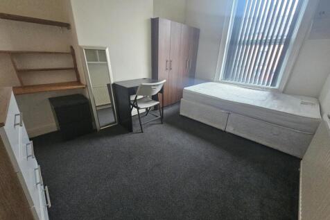 A small, tidy room featuring a basic setup with...