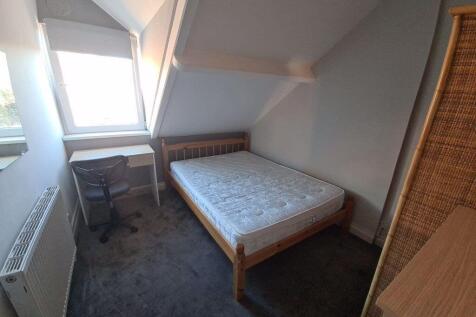Cozy single bedroom with a large skylight windo...