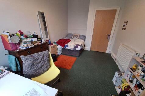 A cozy student bedroom featuring a single bed, ...