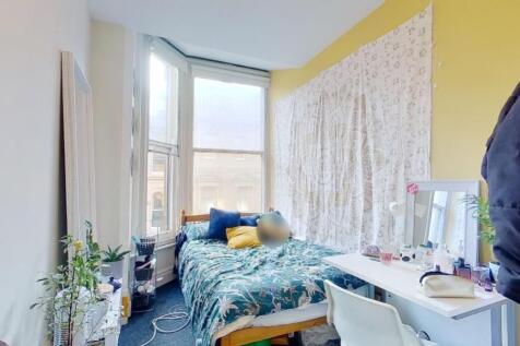 Bright and cozy bedroom featuring a large bay w...