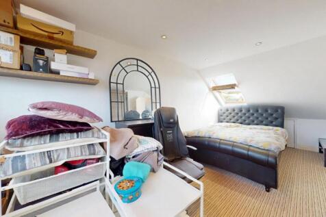 A cozy attic bedroom featuring a comfortable si...