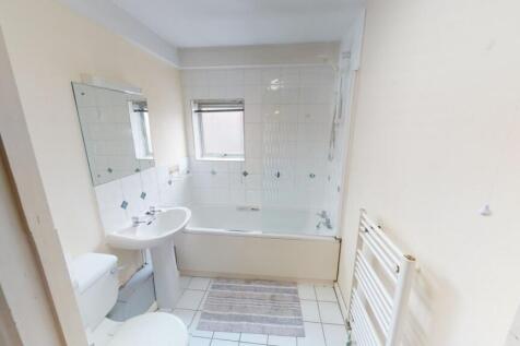 A bright and clean bathroom featuring a white b...
