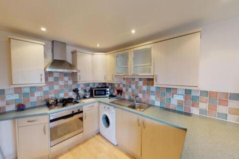 A neat and functional kitchen featuring light w...
