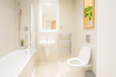 A bright and modern bathroom suite featuring a ...