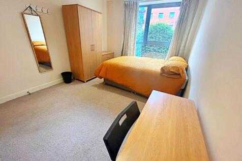 A bright and tidy bedroom featuring a comfortab...