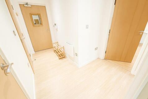 A bright and clean hallway featuring light wood...