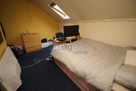 A cozy single bedroom with a sloped ceiling fea...