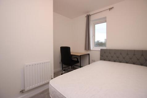 Bright, simply furnished bedroom with a comfort...