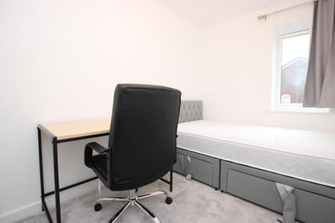 Bright, simply furnished single bedroom with a ...